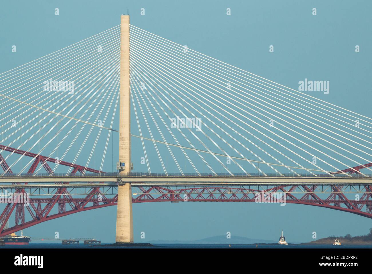 Grangemouth, UK. 8 April 2020.  Pictured: The Queensferry Crossing - Scotland’s newest bridge and the 3rd Firth of Forth crossing which connects Fife and Lothian carrying the M90 Motorway spanning 1.7 miles (2.7km) structure is the longest three-tower, cable-stayed bridge in the world and also by far the largest to feature cables which cross mid-span. This innovative design provides extra strength and stiffness, allowing the towers and the deck to be more slender and elegant. Credit: Colin Fisher/Alamy Live News. Stock Photo