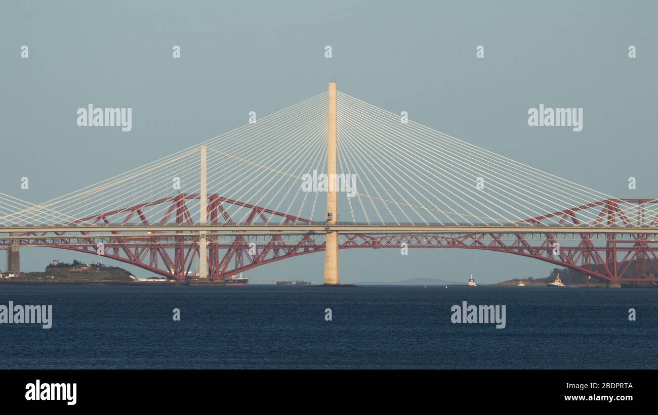 Grangemouth, UK. 8 April 2020.  Pictured: The Queensferry Crossing - Scotland’s newest bridge and the 3rd Firth of Forth crossing which connects Fife and Lothian carrying the M90 Motorway spanning 1.7 miles (2.7km) structure is the longest three-tower, cable-stayed bridge in the world and also by far the largest to feature cables which cross mid-span. This innovative design provides extra strength and stiffness, allowing the towers and the deck to be more slender and elegant. Credit: Colin Fisher/Alamy Live News. Stock Photo