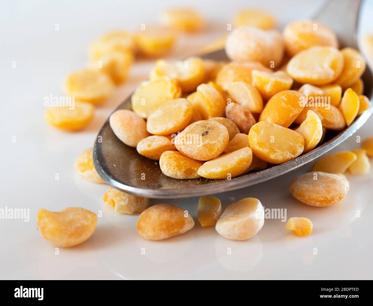 Dried peas in a spoon on white background Stock Photo