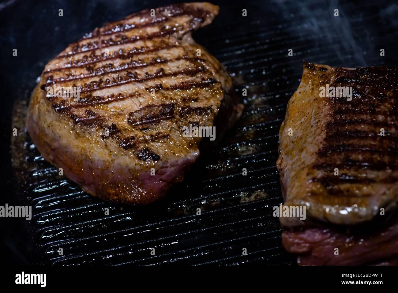 steak on a cast iron griddle Stock Photo