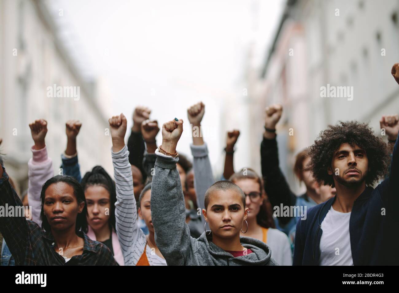 Group of protestors with their fists raised up in the air. Activists