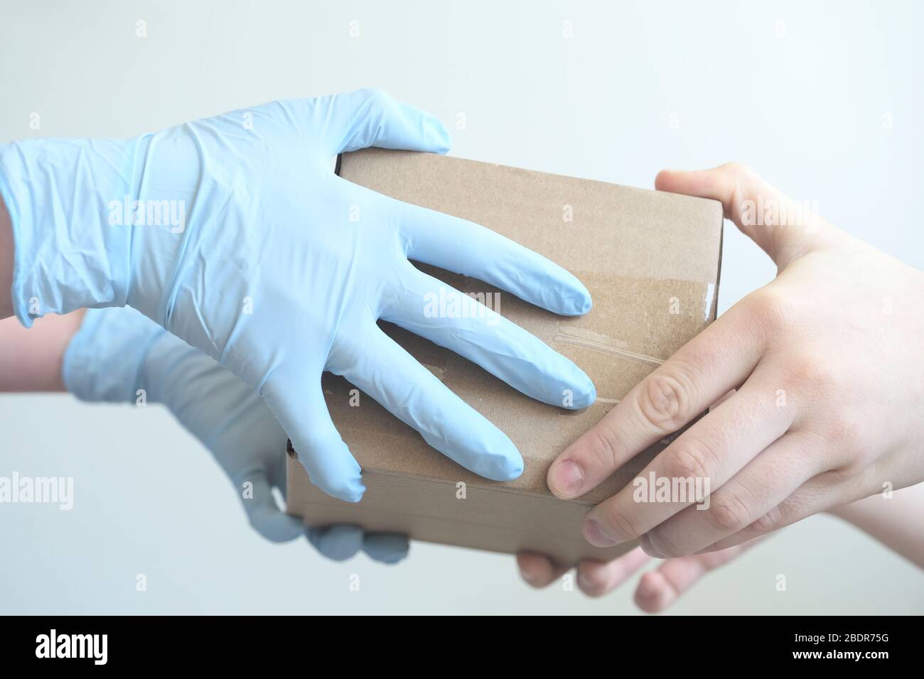 https://c8.alamy.com/comp/2BDR75G/delivery-man-holding-cardboard-boxes-in-medical-rubber-gloves-fast-and-free-delivery-transport-copy-space-online-shopping-and-express-delivery-cl-2BDR75G.jpg