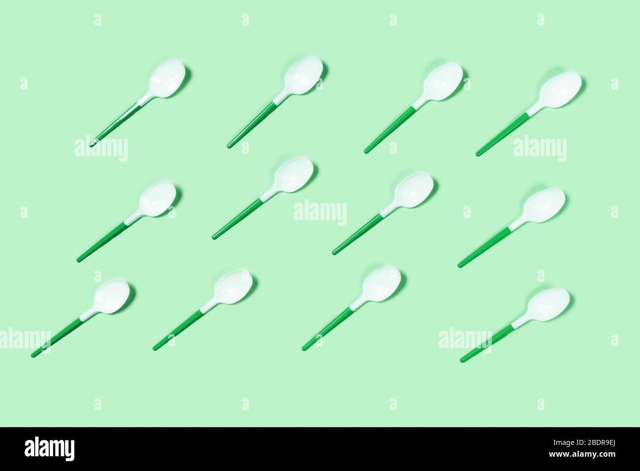 Group of white plastic spoons. Environmental problem of plastic rubbish pollution. Flat lay, top