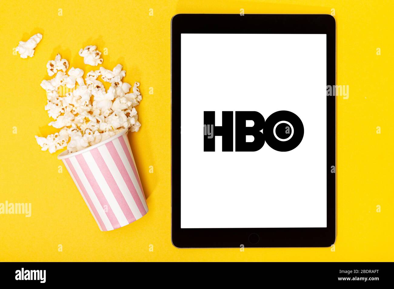 Galicia, Spain. March 9, 2020; Popcorn bucket and tablet with HBO logo on yellow background. Top view Stock Photo