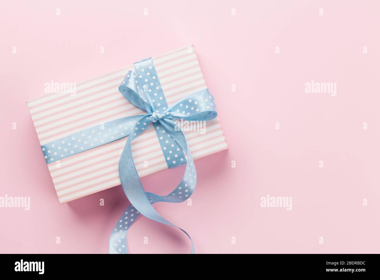 Greeting card with pastel color gift box on pink background. Top view ...