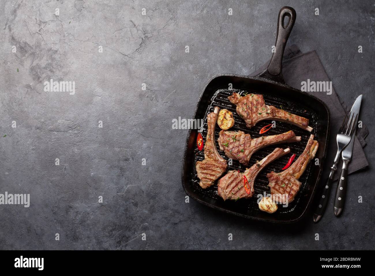 Grilled lamb ribs in frying pan. Hot rack of lamb with spices and ...