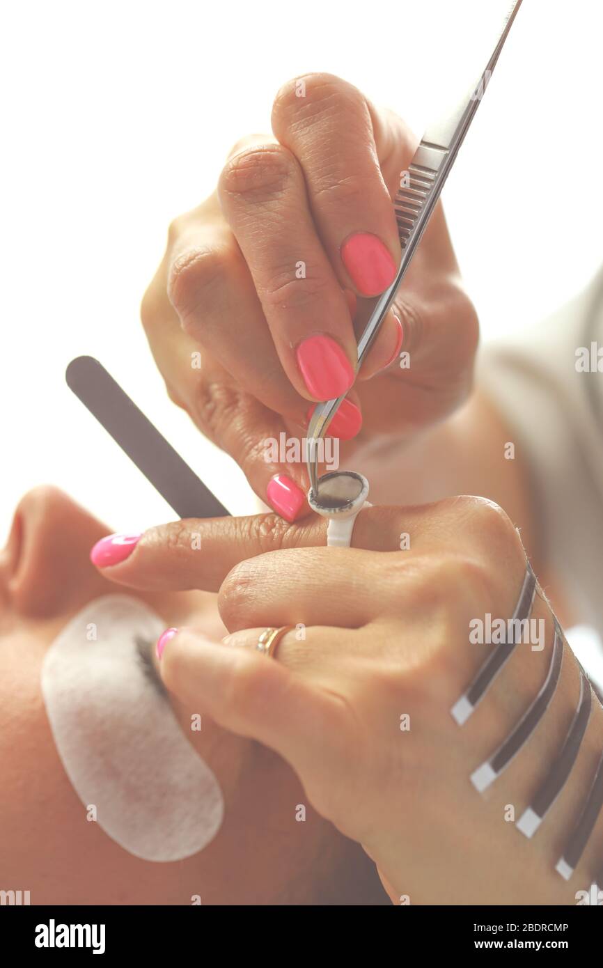 Eyelash Extension Procedure. Selective focus on eyelash extension tool. Beauty and fashion concept Stock Photo
