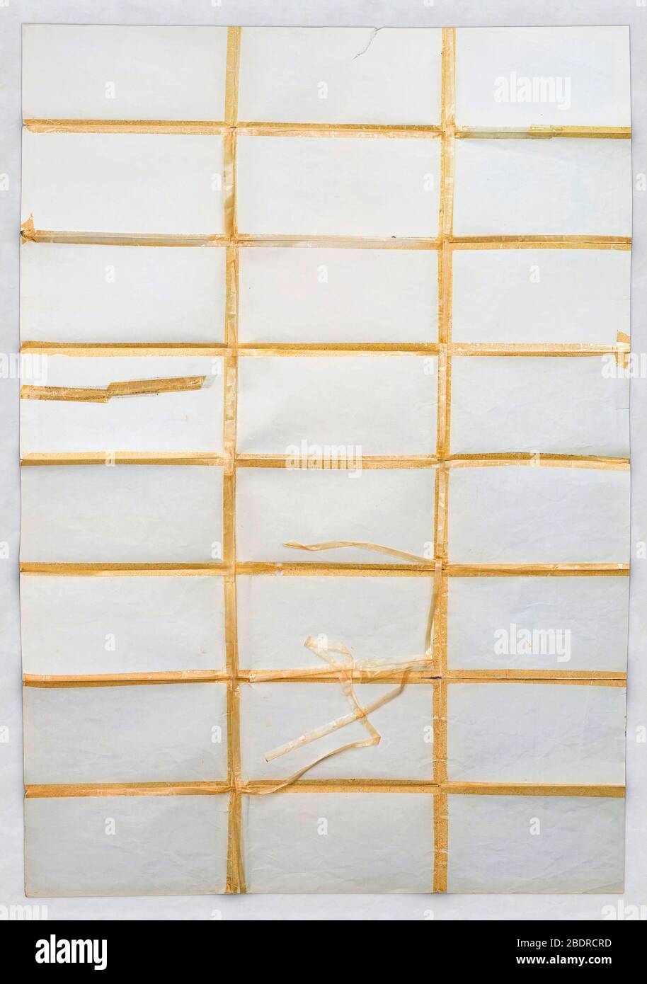 Multiple folded paper with visible scraps of old adhesive tape on white background Stock Photo