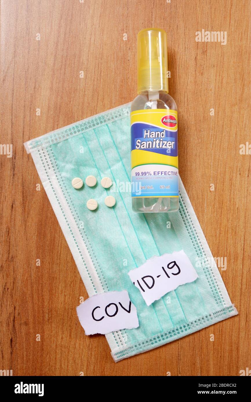 A bottle of hand sanitizer, a medical masker and white vitamin pills as prevention to Covid-19 . Stock Photo