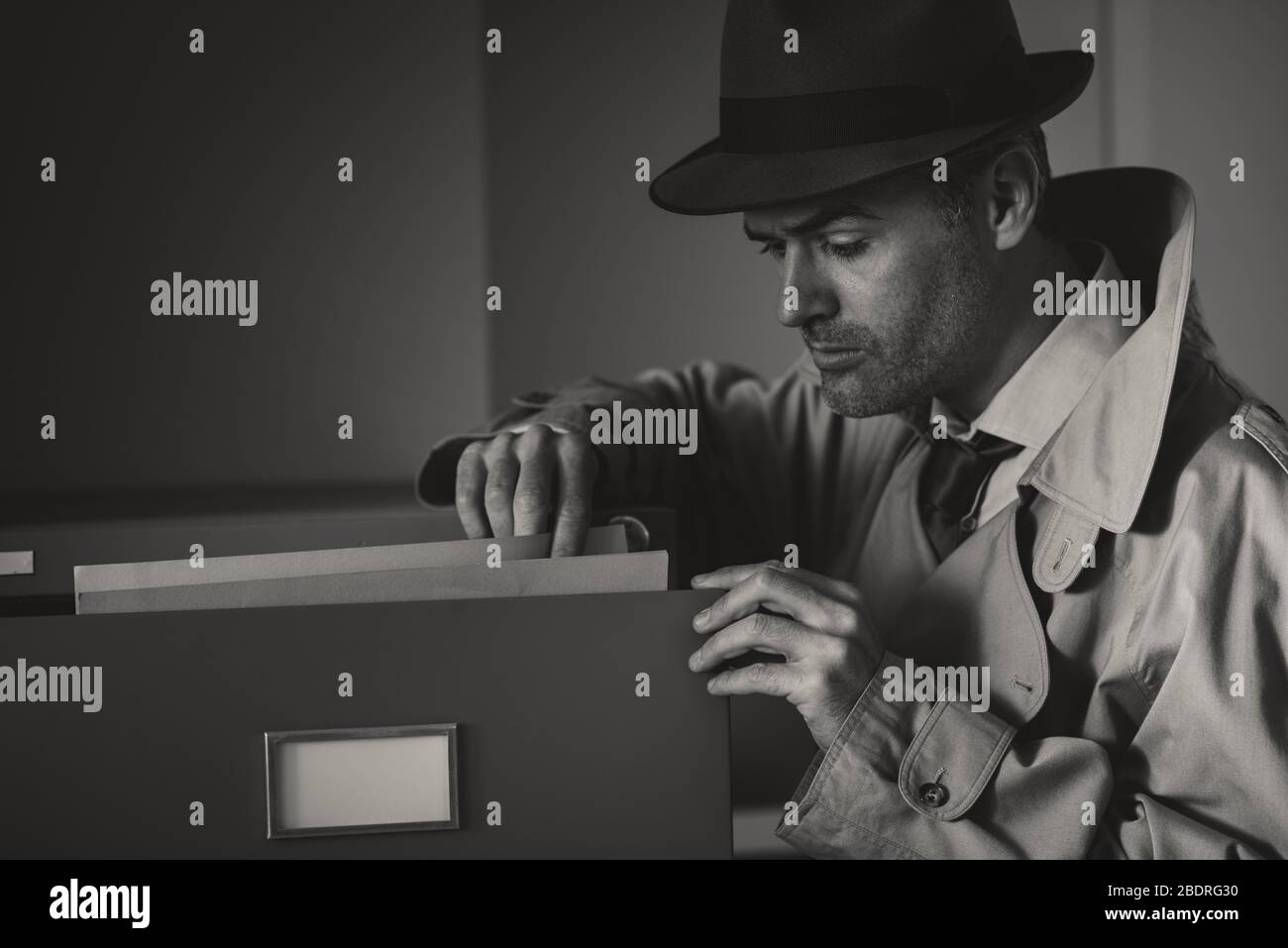 Vintage undercover criminal spy stealing files in a filing late