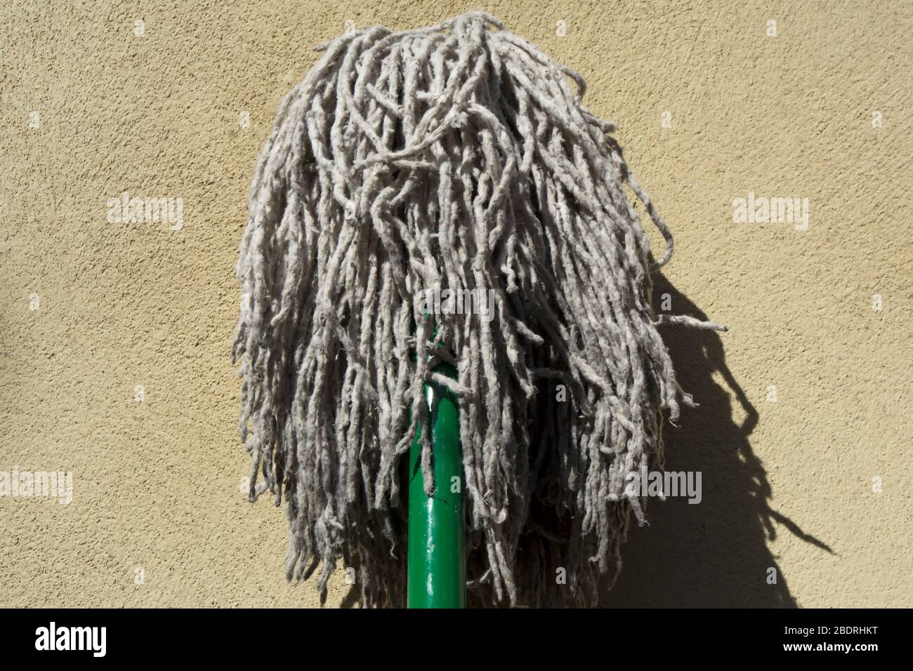 head of a mop, turned upside down and drying in sunlight against a wall  Stock Photo - Alamy