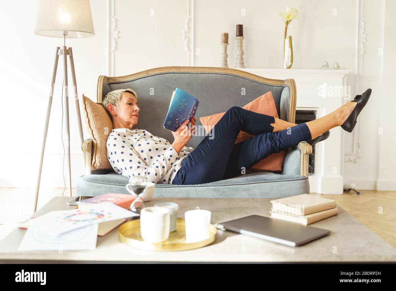 Aged female astrologer lying on a sofa Stock Photo