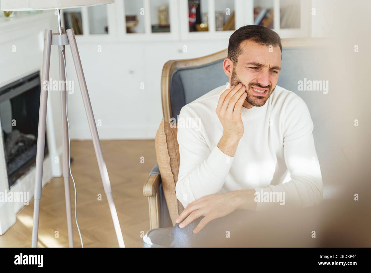 Frustrated short-haired young man having a toothache Stock Photo