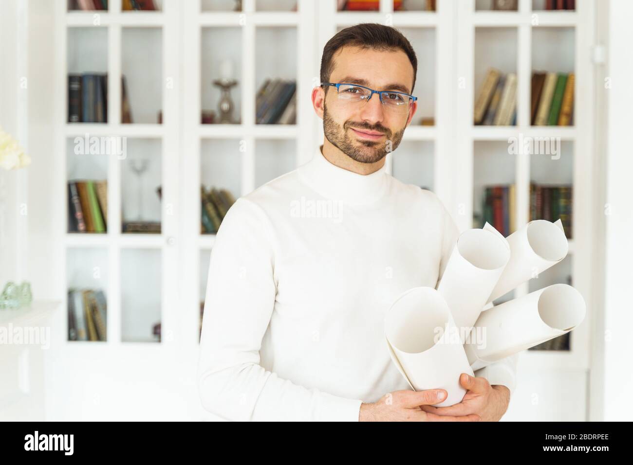 Smiling man in a white pullover looking forward Stock Photo