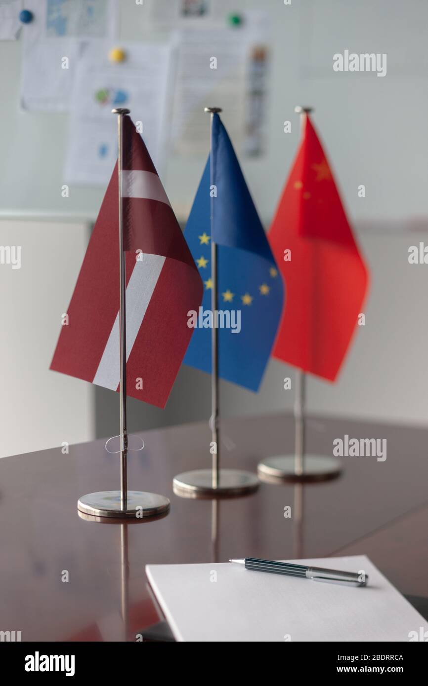 Latvian, Chinese and EU flag on the table Stock Photo