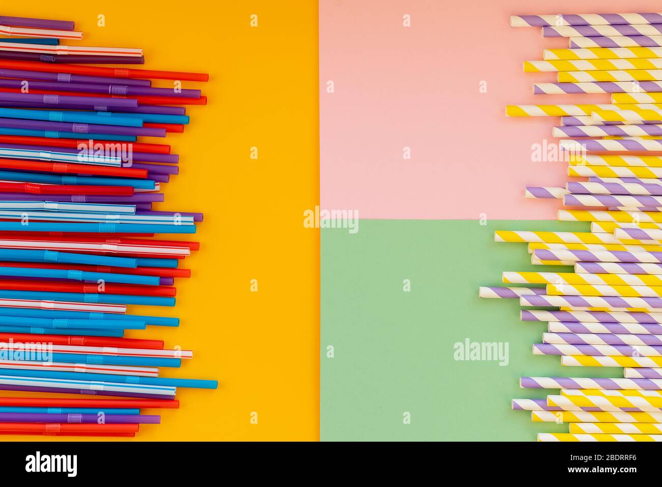 Paper straws vs plastic straws on colorful background.colored tubules for juice and cocktails