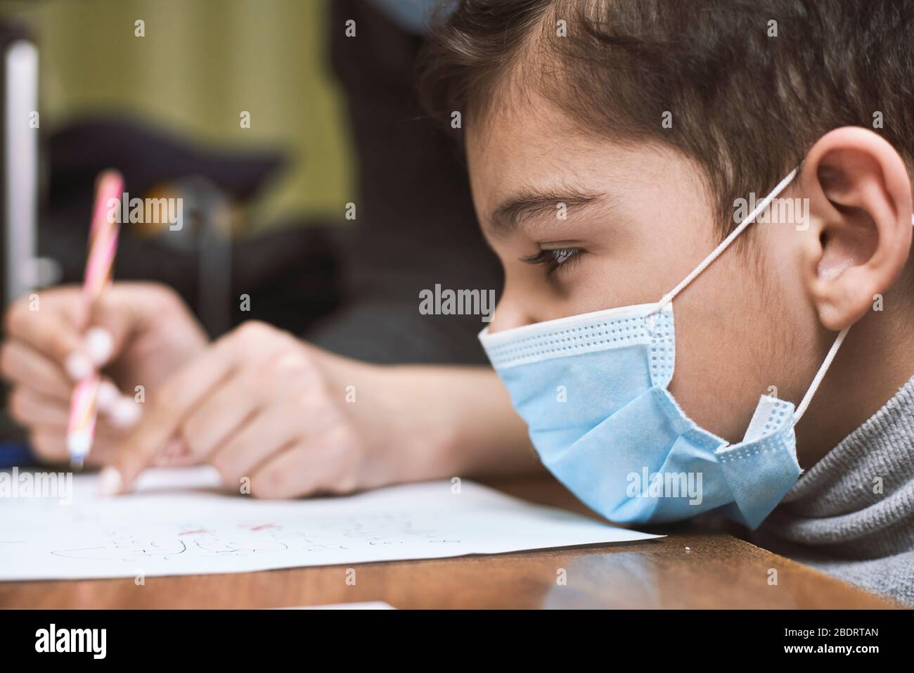 Distance education. Mother helps pre-school kid to do lessons. Education at quarantine time. Protection of Children during the Coronavirus Pandemic Stock Photo