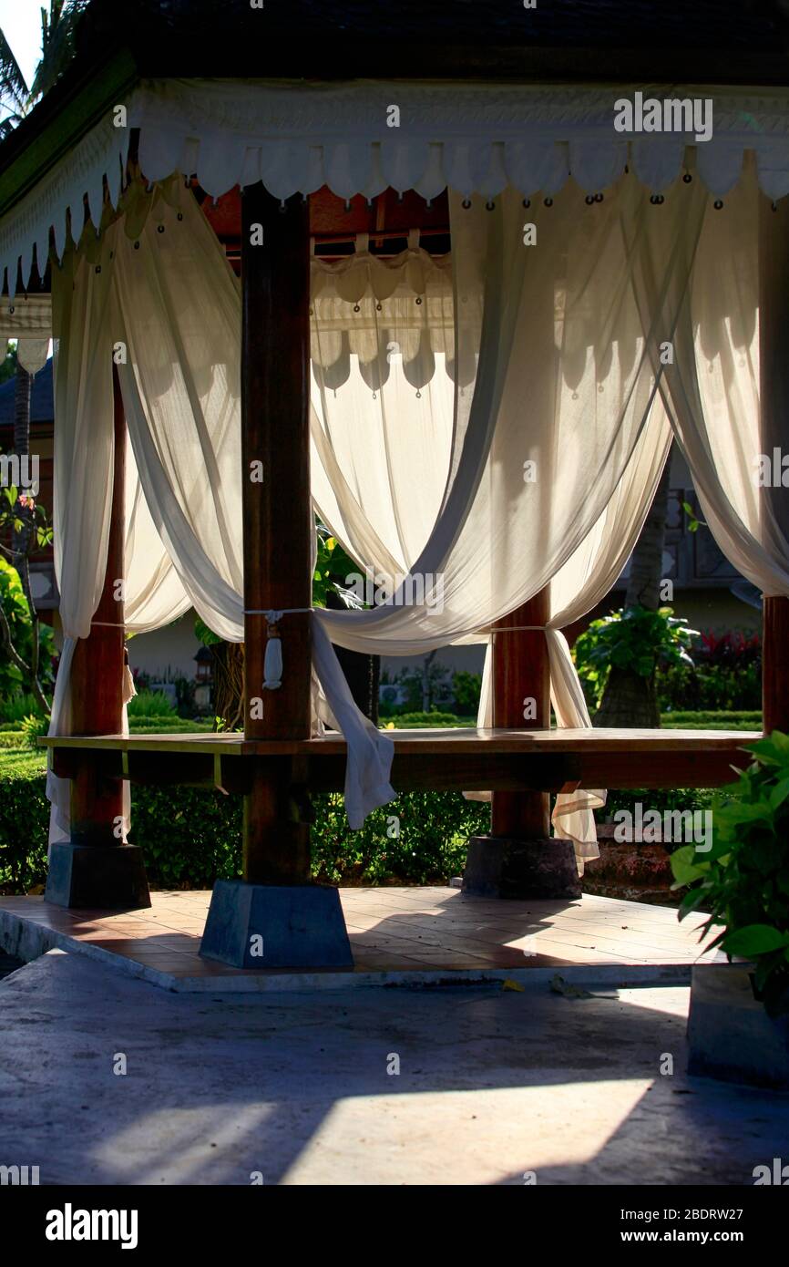 Arbor with white curtains for relaxation or meditation. Bali Island, Indonesia. Stock Photo