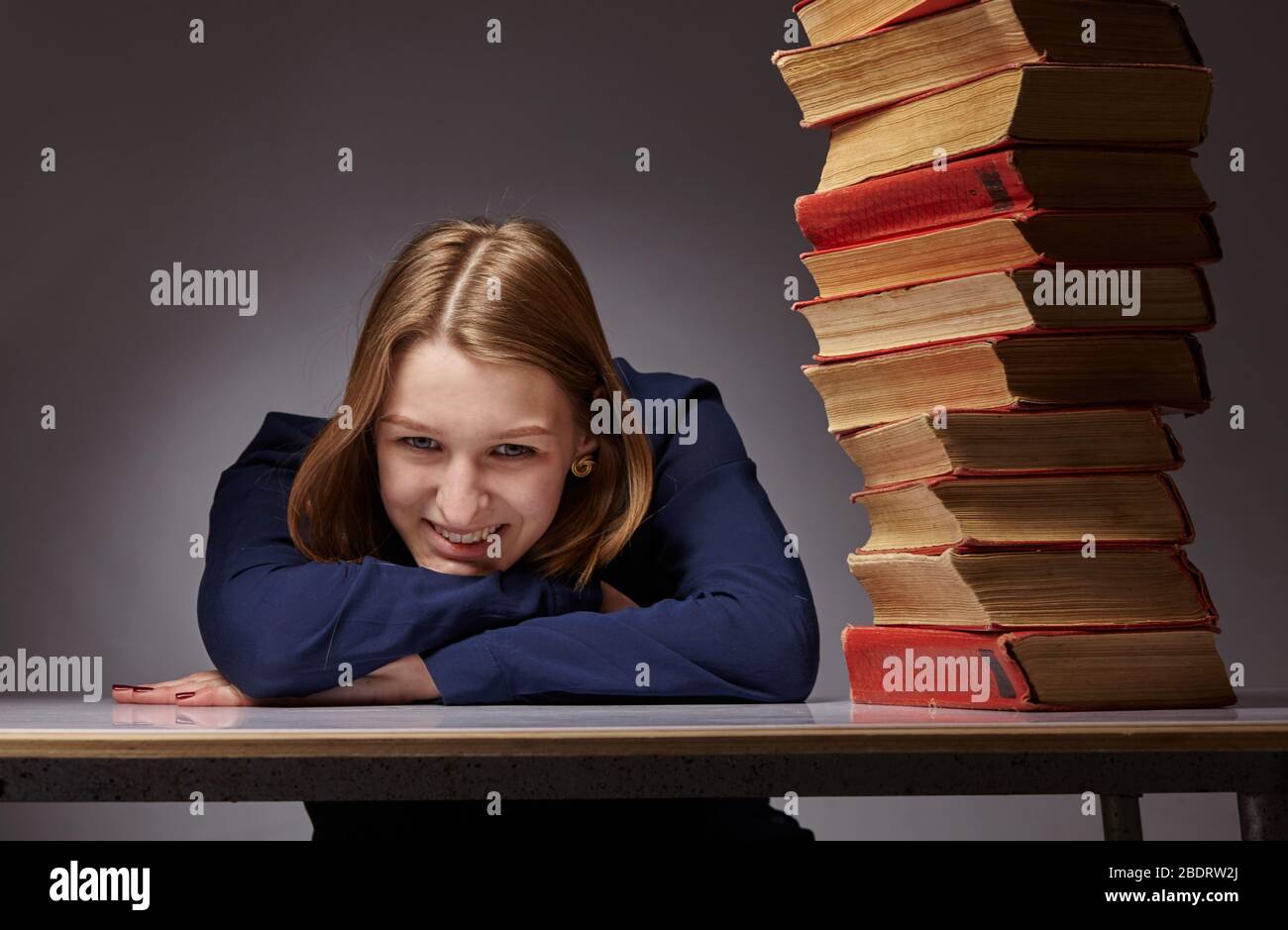 Girl with pile of books hi-res stock photography and images - Alamy