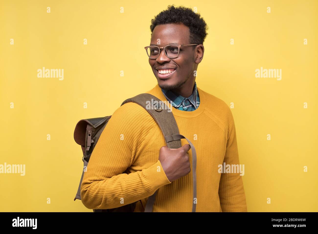 college student holding backpack and smiling being glad to study Stock Photo