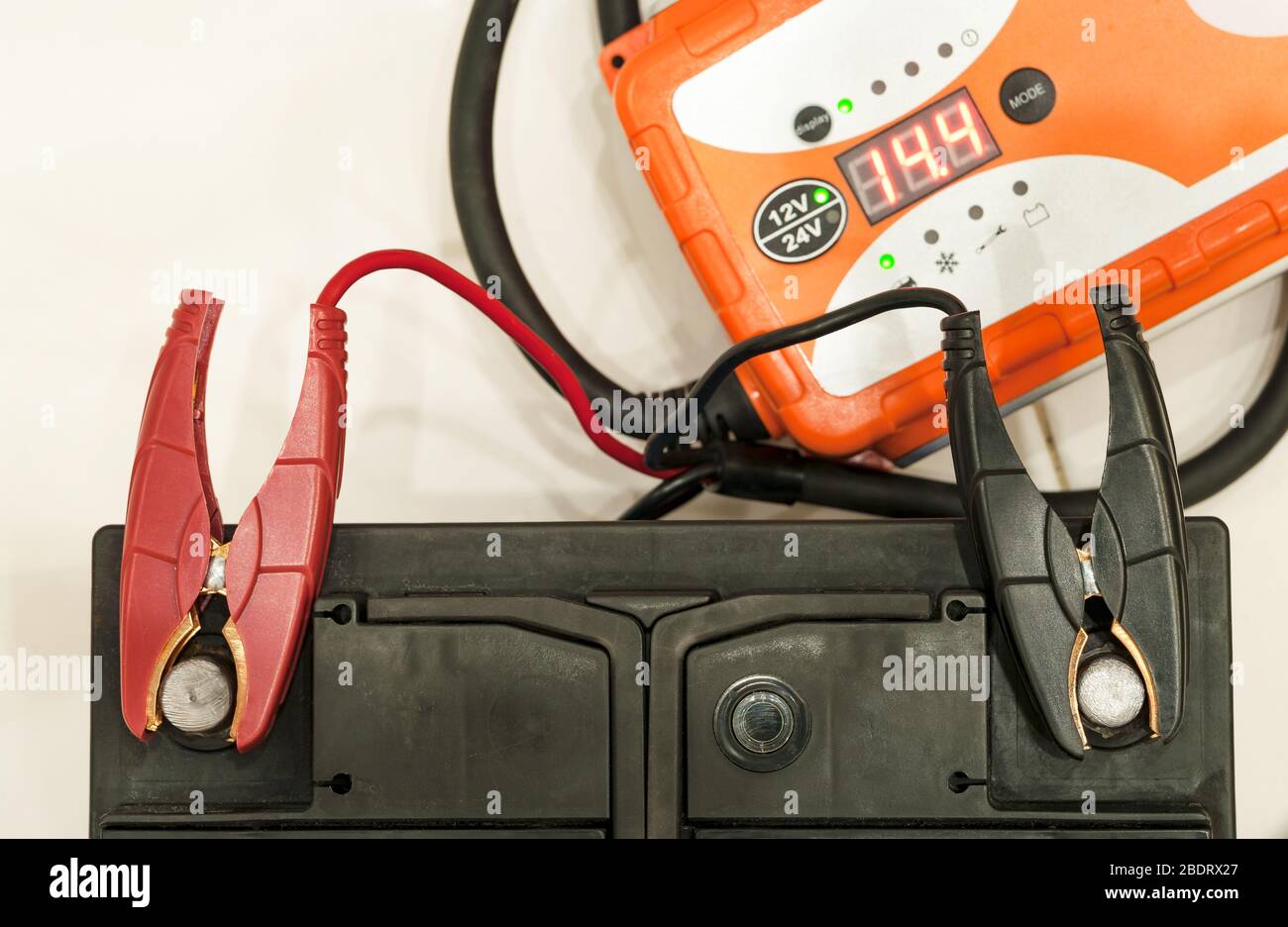 Recharging the car battery with red and black copper clips attached to