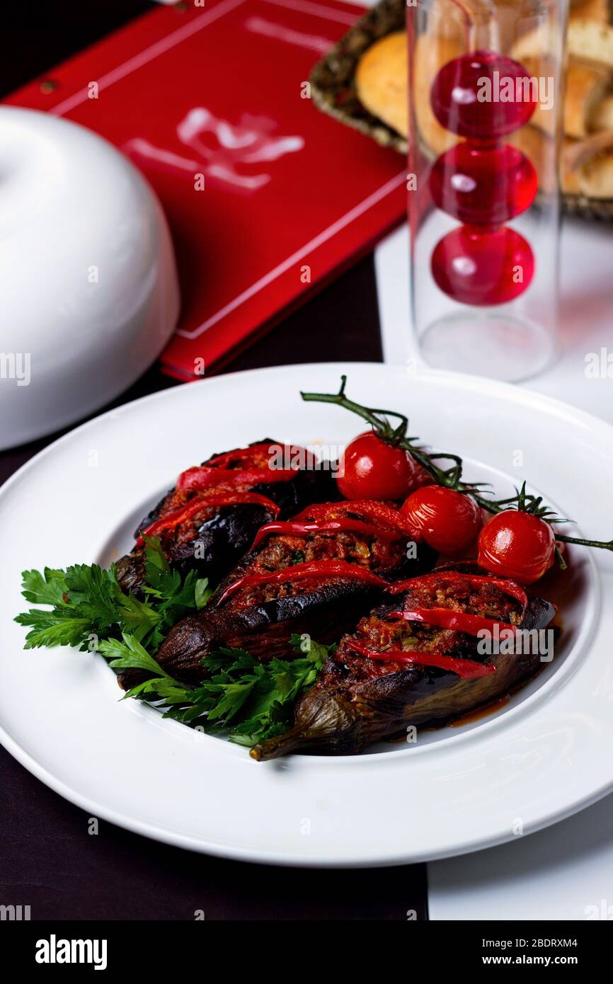 smoked aubergine with minced meat garnished with cherry tomato and parsley Stock Photo