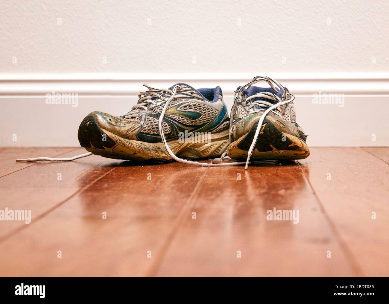 A pair of worn out running shoes on the floor Stock Photo Alamy