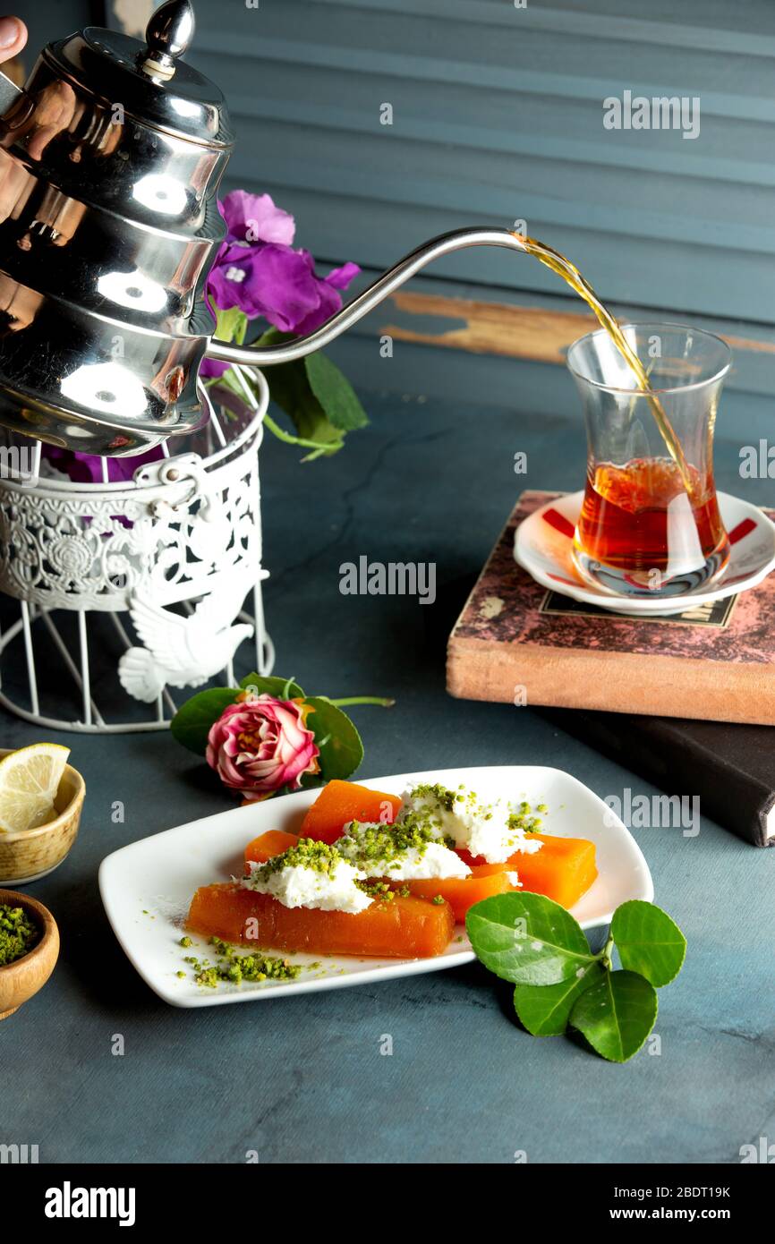 a serving of quince dessert topped with cream and pistachio served with