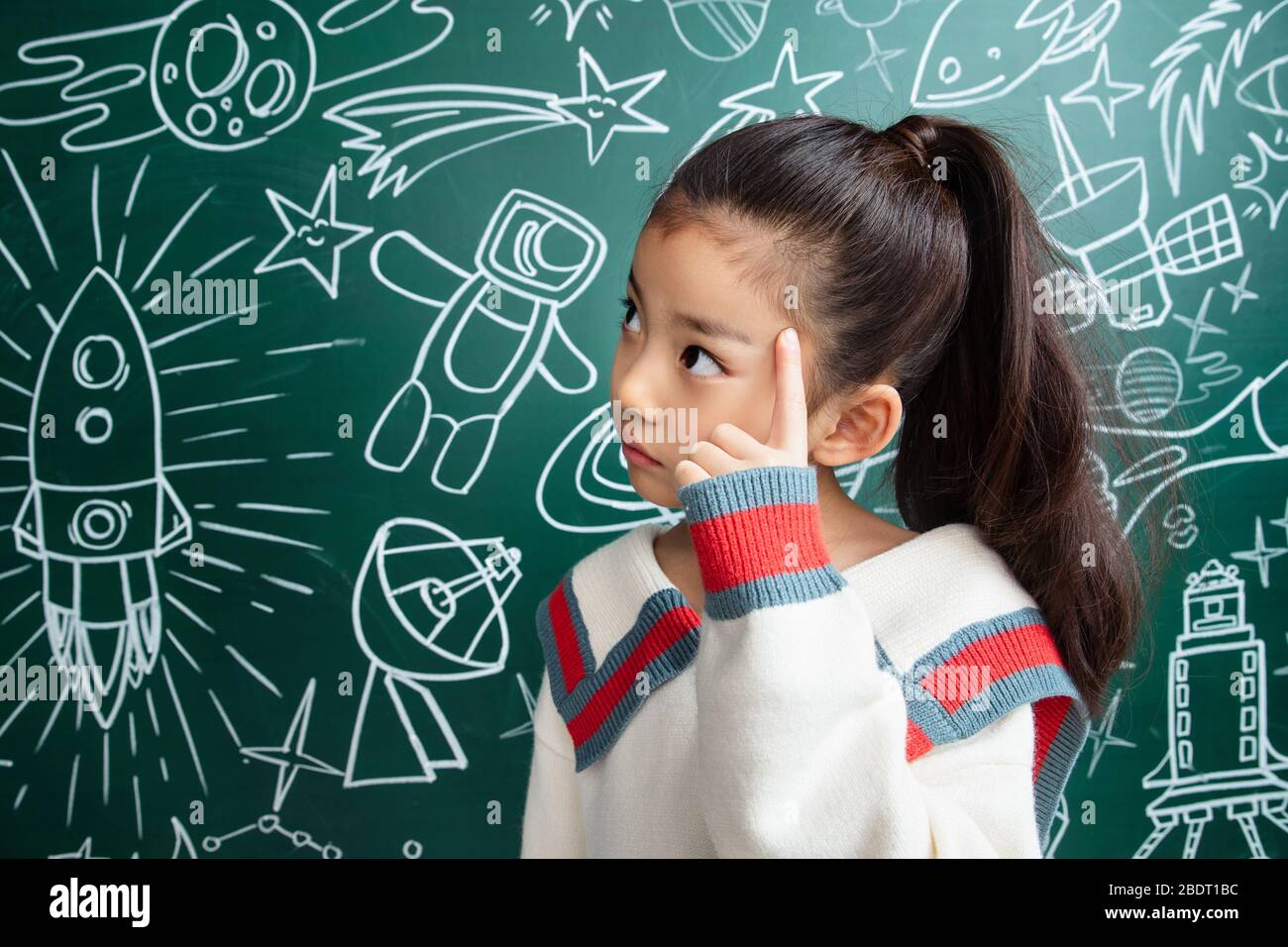 The little girl standing in front of the blackboard Stock Photo - Alamy