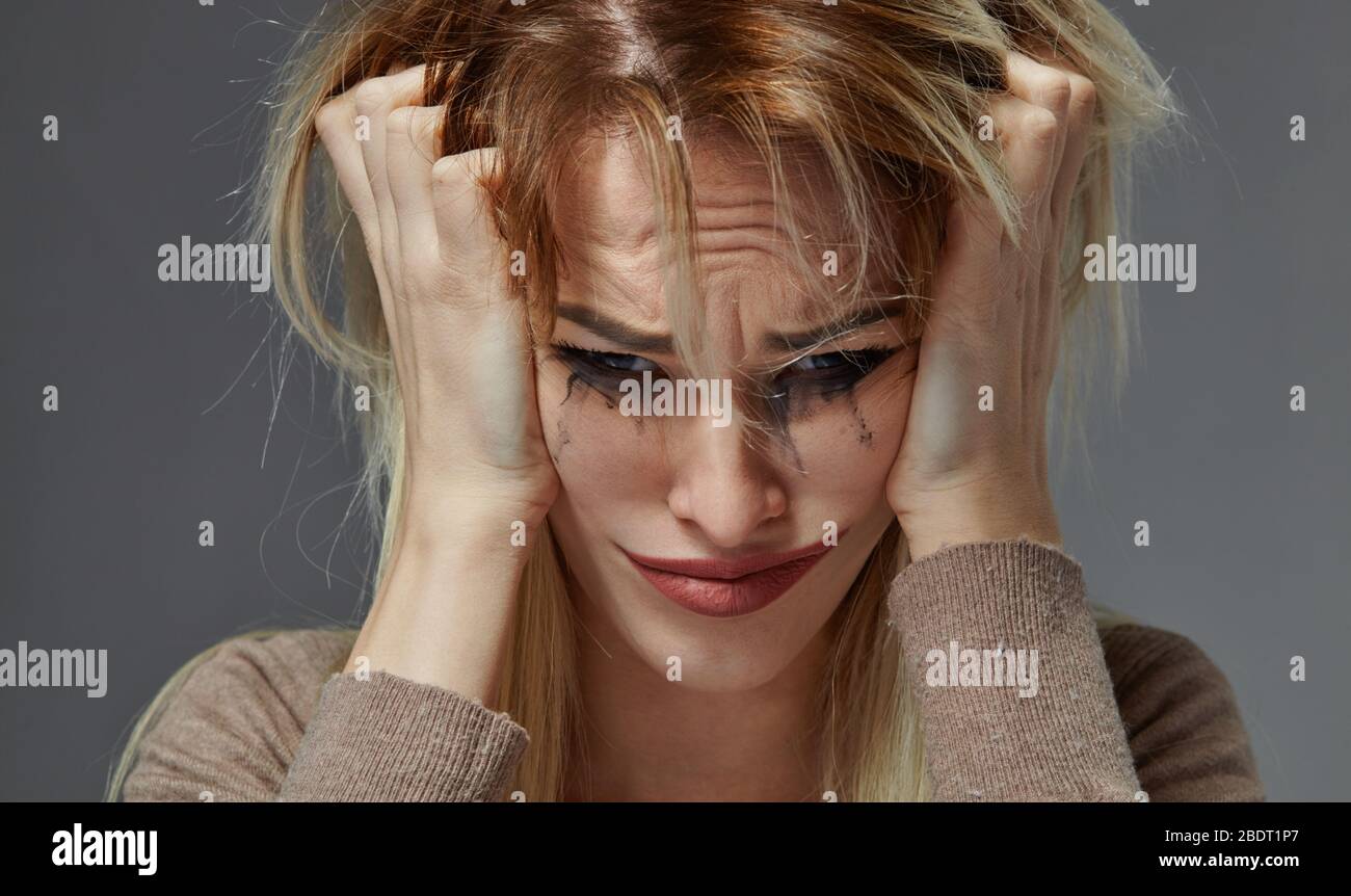 woman suffering from stress or headache while being offended by pain Stock Photo