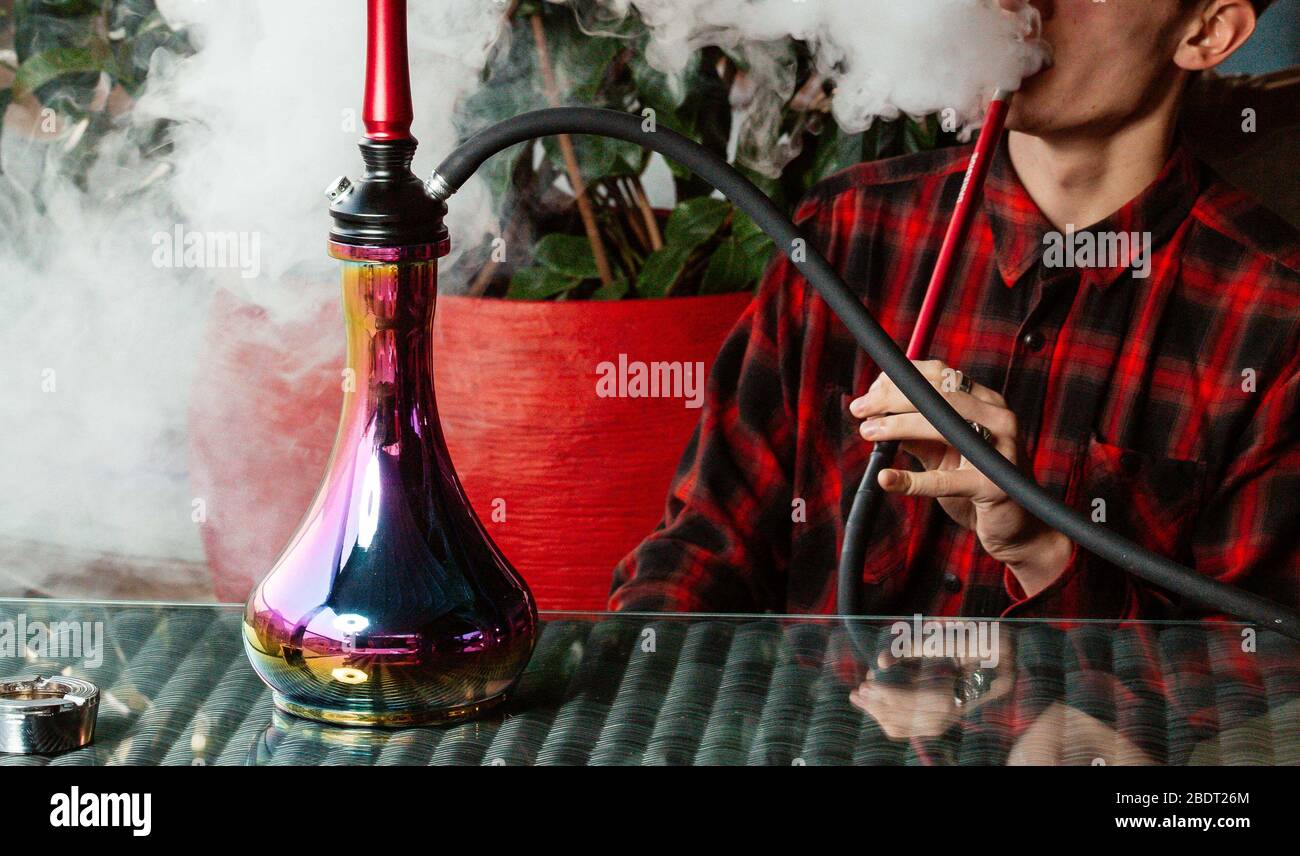 close up of man blowing hookah smoke from pipe Stock Photo - Alamy, image size:1300x856