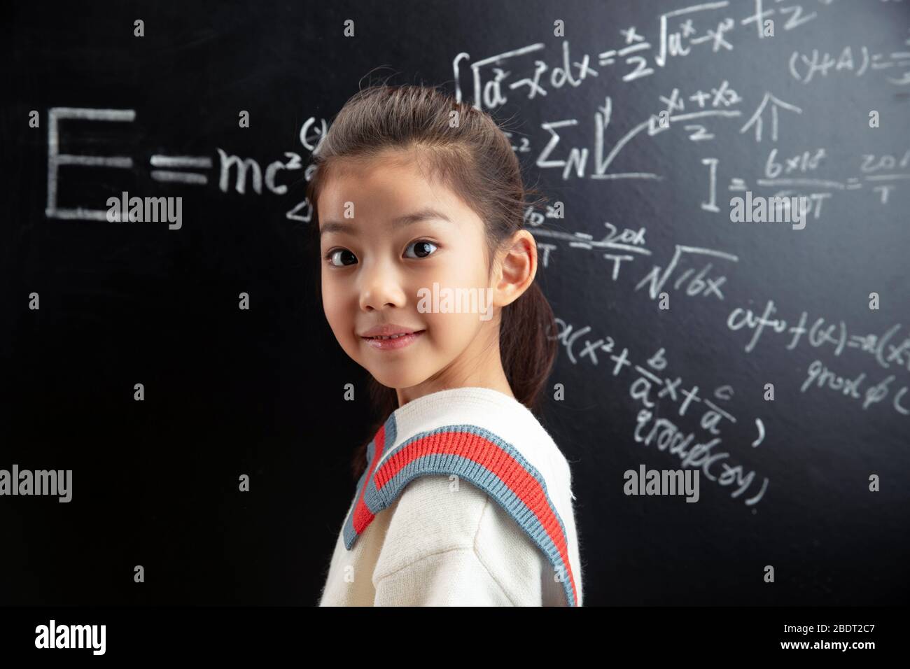 The little girl standing in front of the blackboard Stock Photo - Alamy