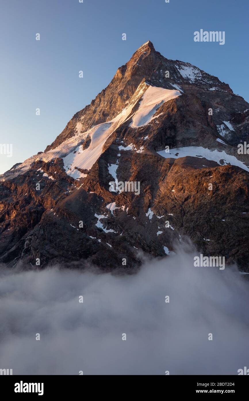 Sunlight at sunrise. The Matterhorn (Cervino), north-west ridge, called Zmutt ridge (Zmuttgrat). Glaciers. Swiss Alps. Europe. Stock Photo