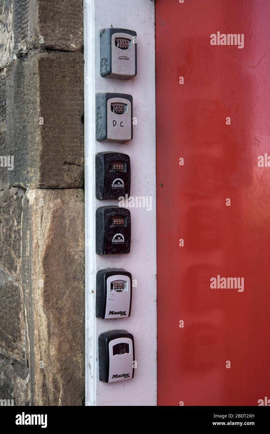 Six key safes for Airbnb or short term lets by the door to a tenement at Granton, Edinburgh, Scotland, UK. Stock Photo