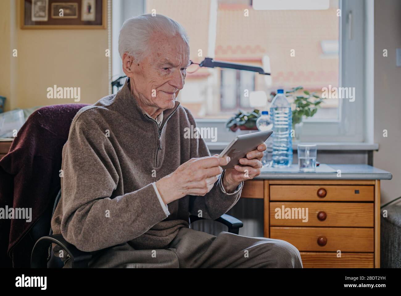 Positive Senior using Digital Tablet Stock Photo