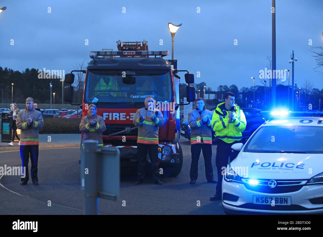 Members of the Northumberland Fire and Rescue Service applauding outside Crammington Hospital in Northumberland, saluting local heroes during Thursday's nationwide Clap for Carers NHS initiative to applaud NHS workers fighting the coronavirus pandemic. Stock Photo