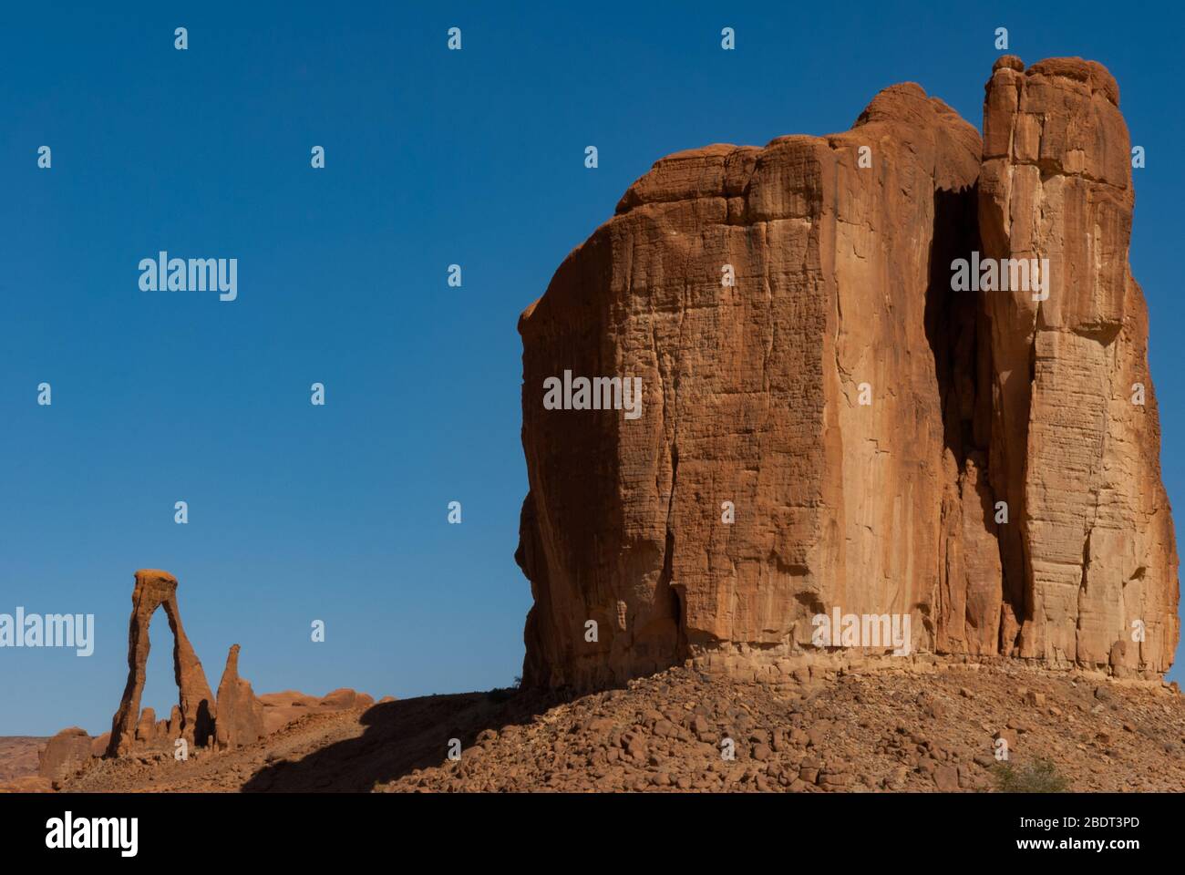 Abstract rocks formation at plateau Ennedi, one in lyre shape in the background, in Sahara desert, Chad, Adrica Stock Photo