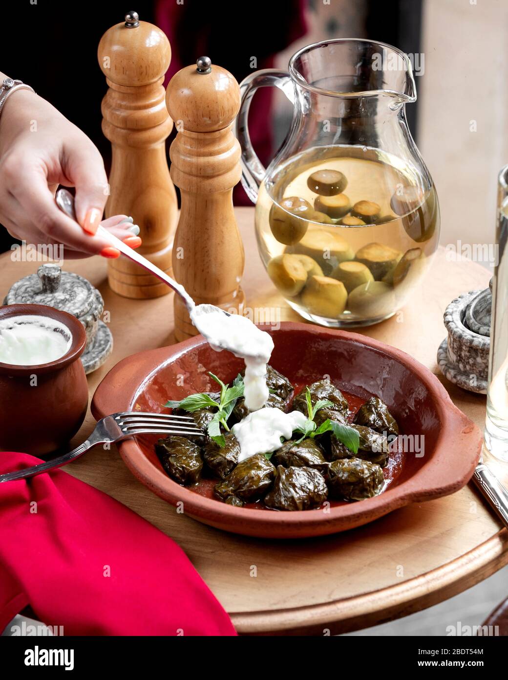 woman putting yogurt on stuffed grape leaves dolma Stock Photo Alamy