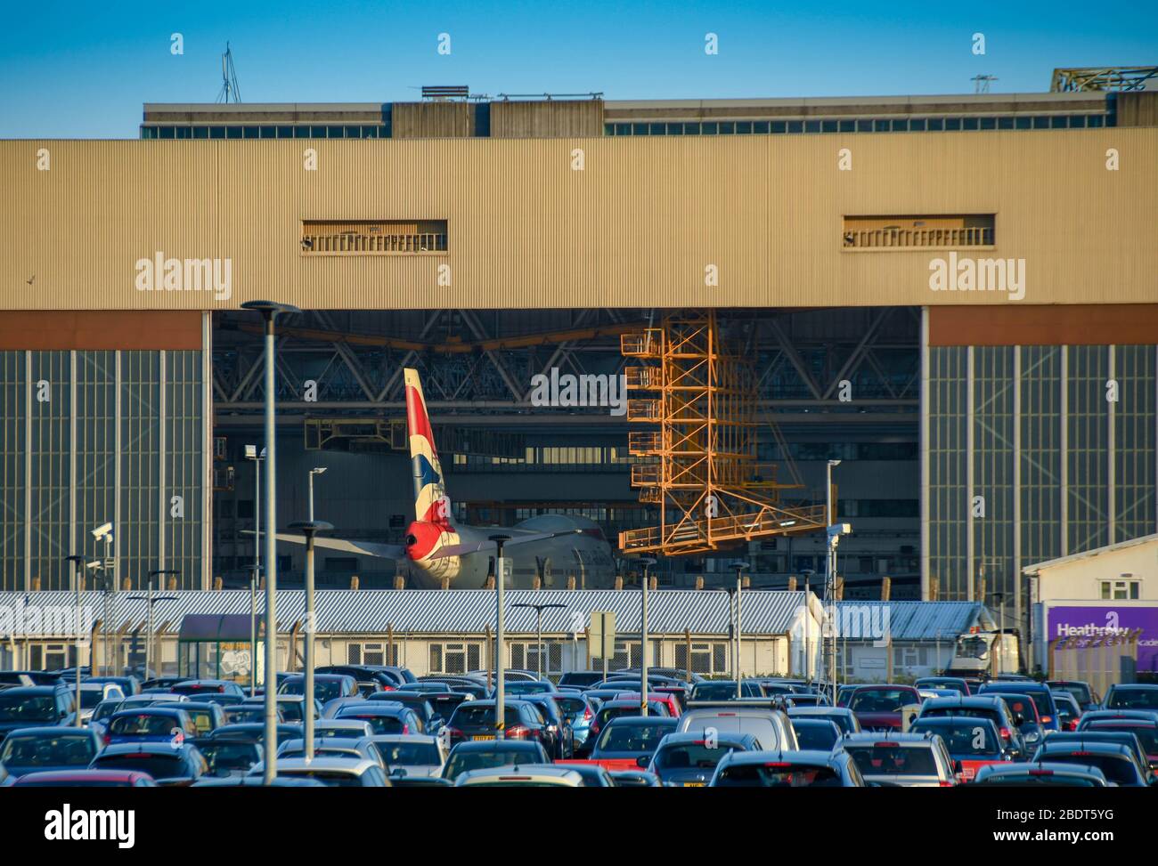 LONDON HEATHROW AIRPORT - JUNE 2018: British Airways maintenance hangar at London Heathrow airport with doors open and a plane being serviced Stock Photo