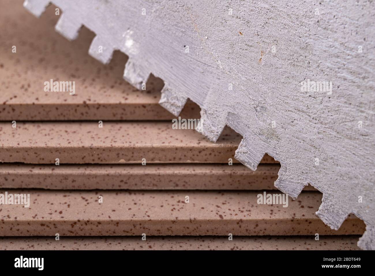 Industrial tiles and trowel with comb for tiling. Accessories for