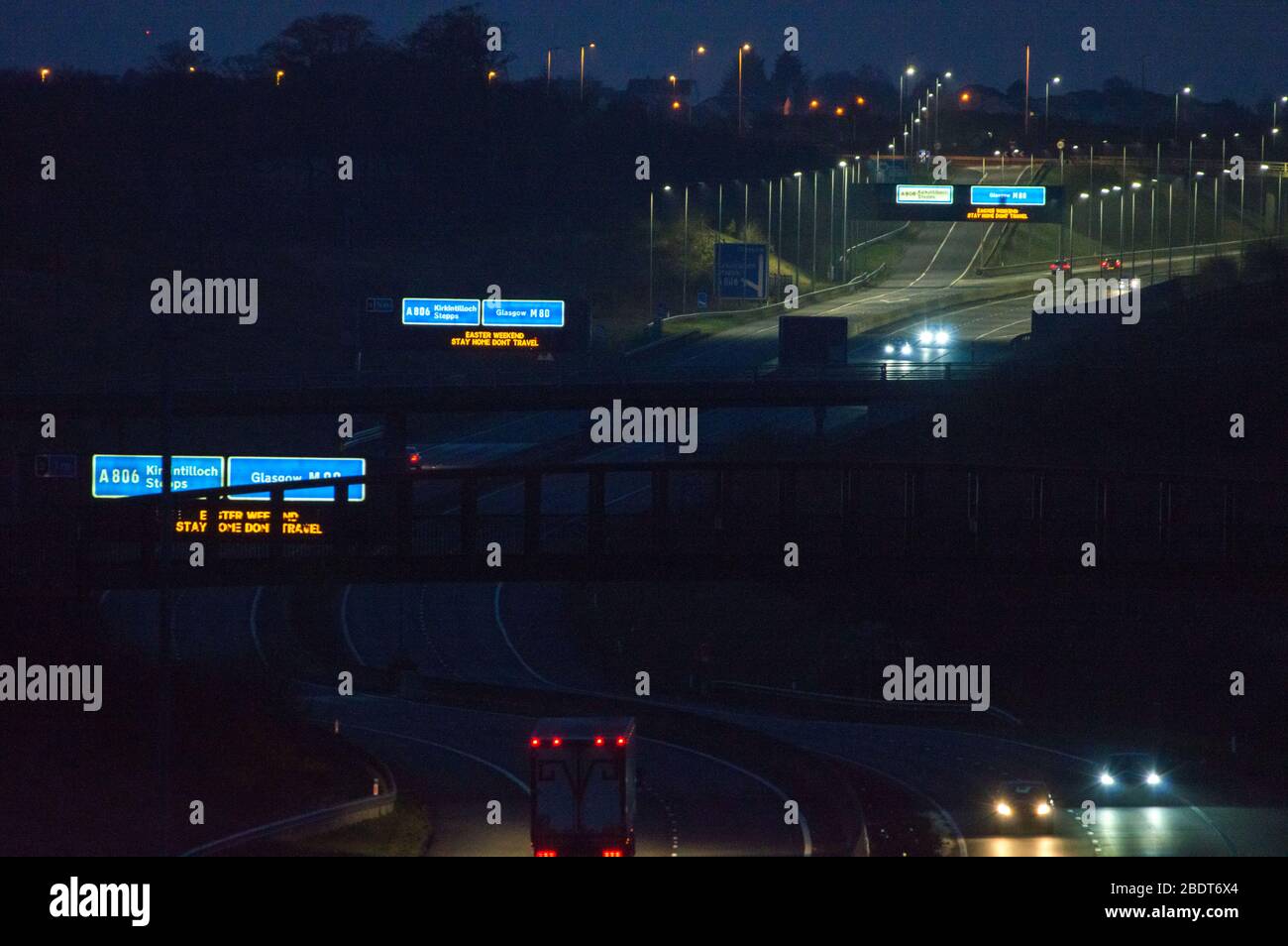 Glasgow, UK. 9th Apr, 2020. Pictured: Road signs all along the M8 and M80 motorways which read, “EASTER WEEKEND STAY HOME DONT TRAVEL” The Coronavirus Pandemic has forced the UK Government to order a shut down of all the UK major cities and make people stay at home, which has left the motorways and all other roads free of the usual nose to tail traffic which would otherwise be there. Credit: Colin Fisher/Alamy Live News Stock Photo