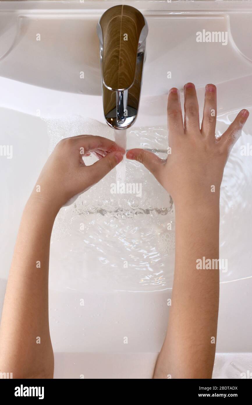 The child learns to wash the nails zone with water in the sink Stock Photo  - Alamy
