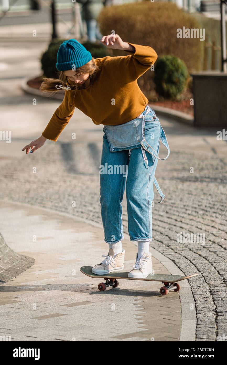 Skateboarding Woman In The City. Skater girl in denim is riding her