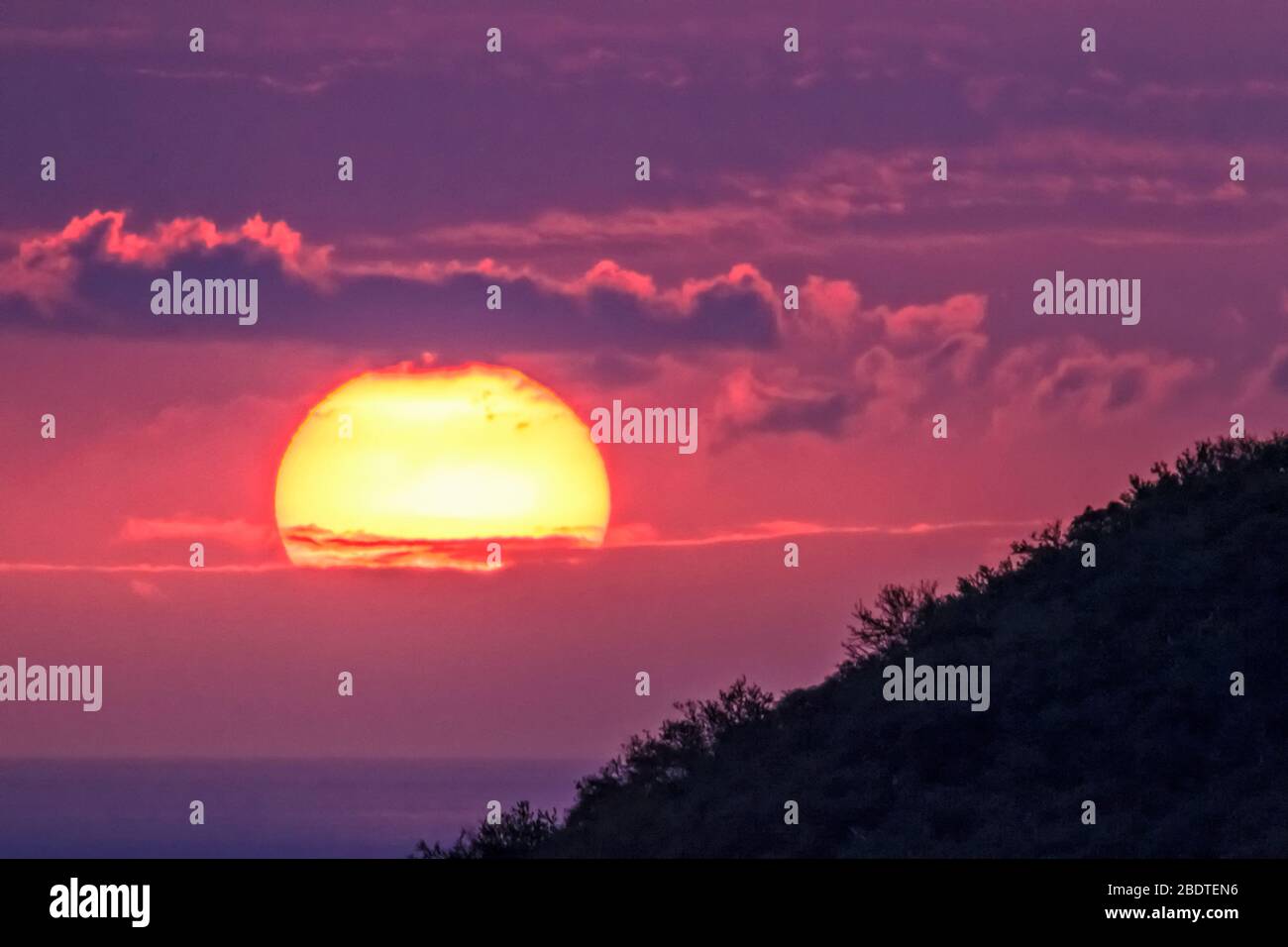 Telephoto super sunset in South Kona, Hawaii Stock Photo