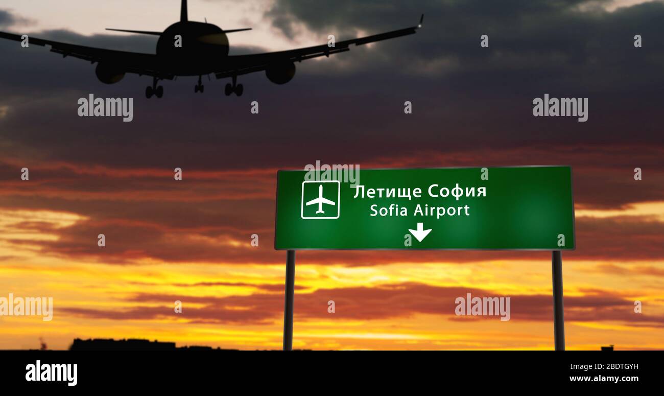 Airplane silhouette landing in Sofia, Bulgaria. City arrival with airport direction signboard and sunset in background. Trip and transportation concep Stock Photo