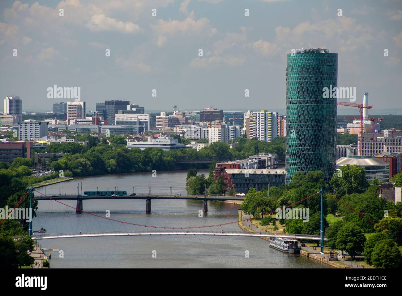 Westhafen Tower and Holbeinsteg bridge with the city of Frankfurt beyond Stock Photo