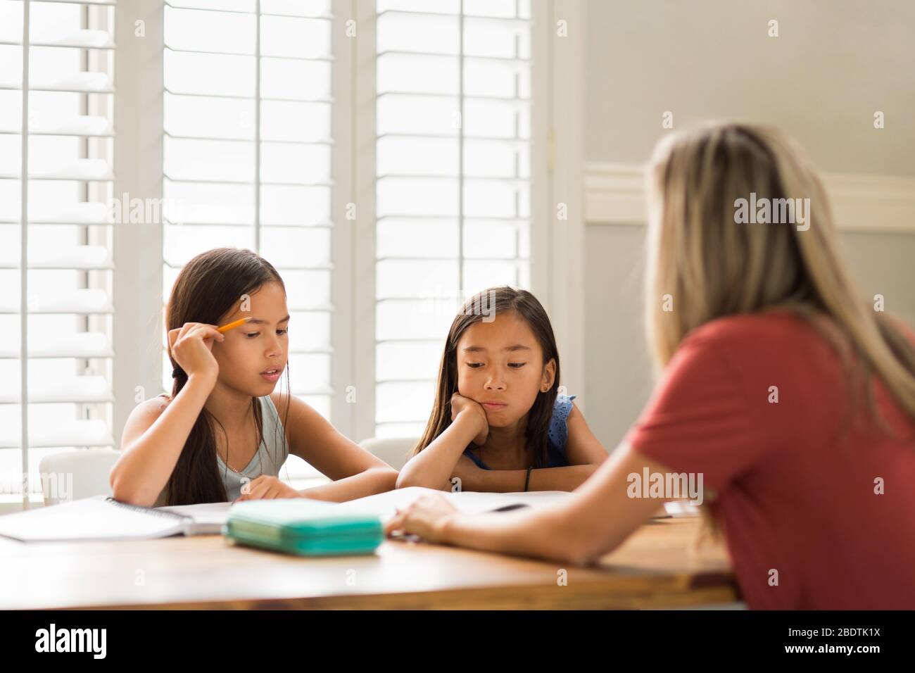 Mother Helping Her Daughters With Their Homework Stock Photo - Alamy