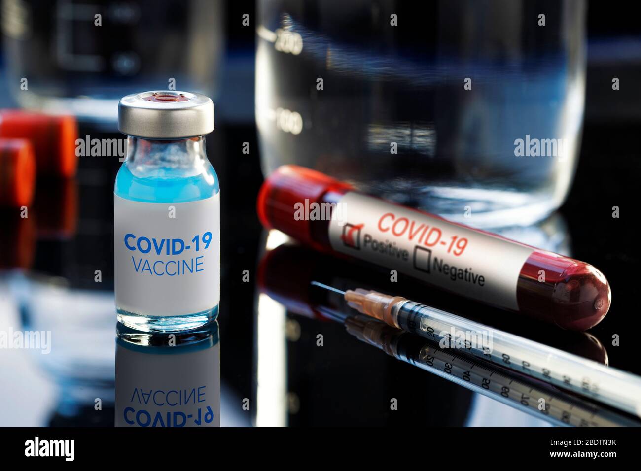 Covid-19 Written vaccine bottle with a blue liquid, a syringe and a ...