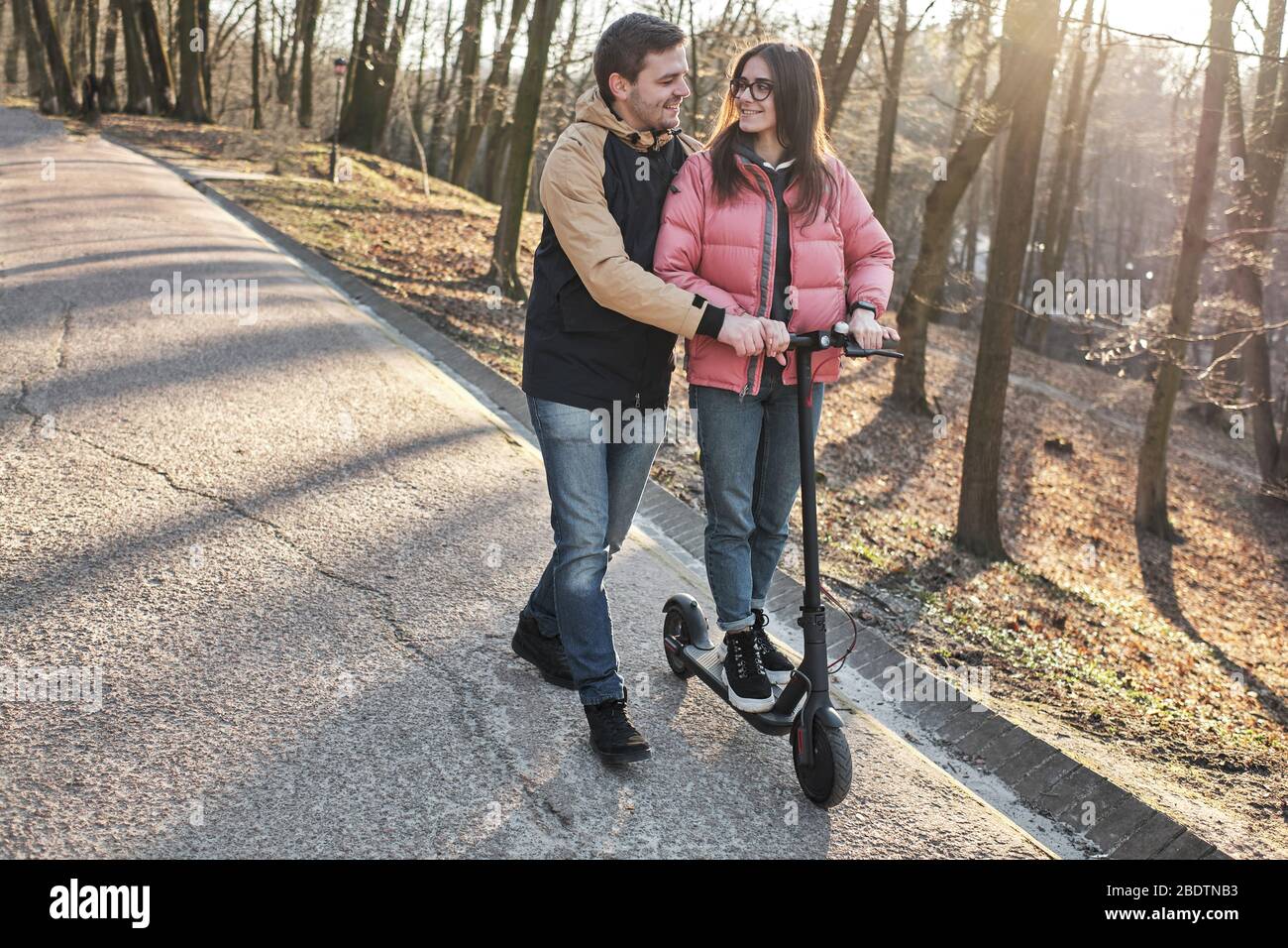 loving young millennials having fun walking on an electric scooter Stock Photo