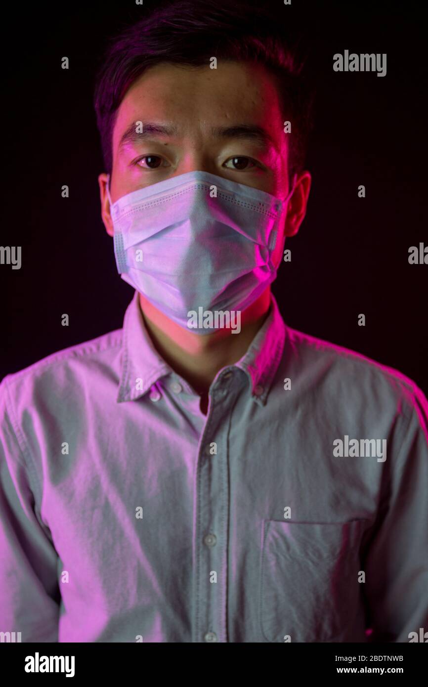 Portrait of asian young man in medical mask. Black background. Red ...